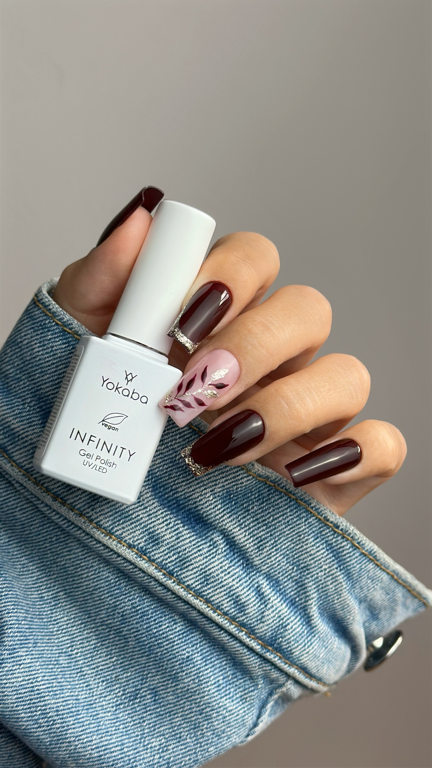 Jesienny manicure w czekoladowym bordo ze złotym frenchem i roślinnymi zdobieniami - zdjęcie 4