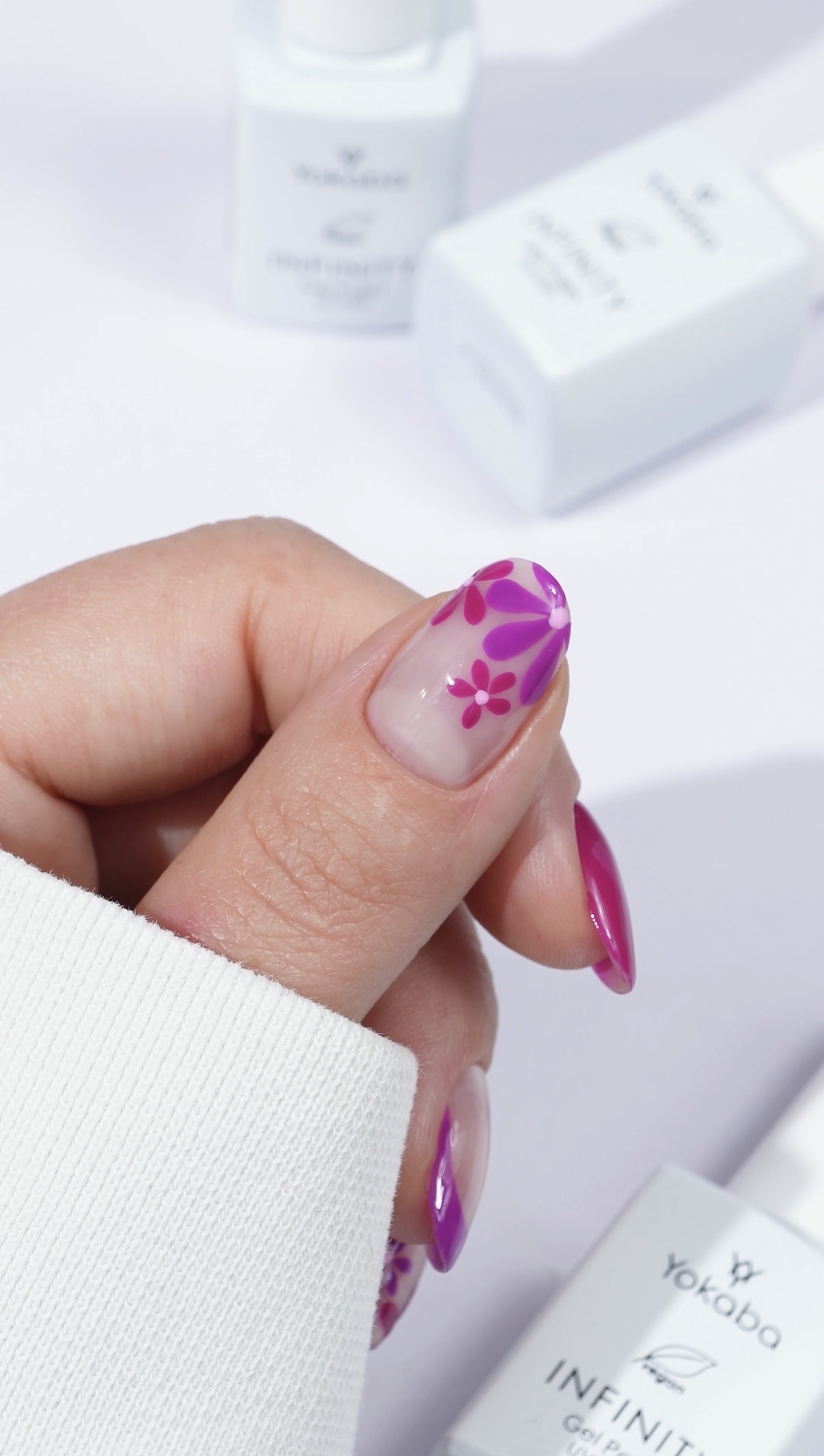 Różowy manicure z kwiatowymi zdobieniami na transparentnej bazie - zdjęcie 3