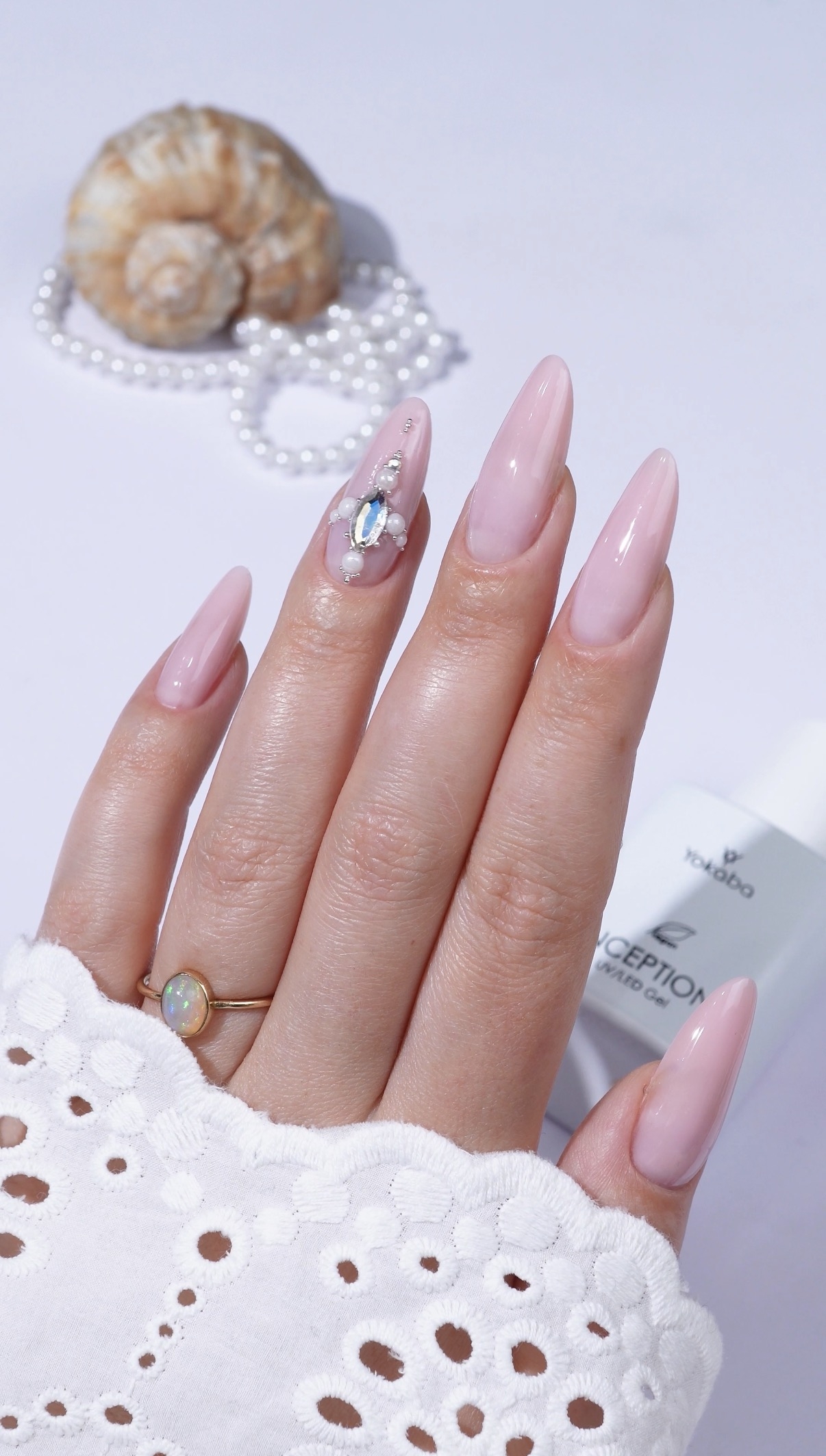Delikatny manicure w mlecznym różu z biżuteryjnym akcentem - zdjęcie 2